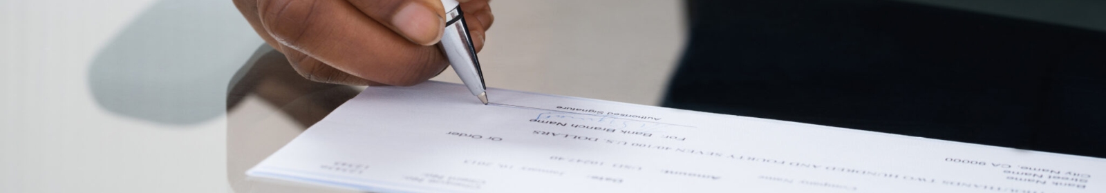 a person signing a papercheck