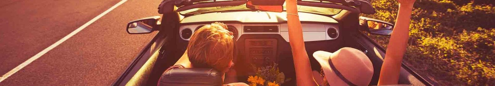A couple riding in a convertible on a country road
