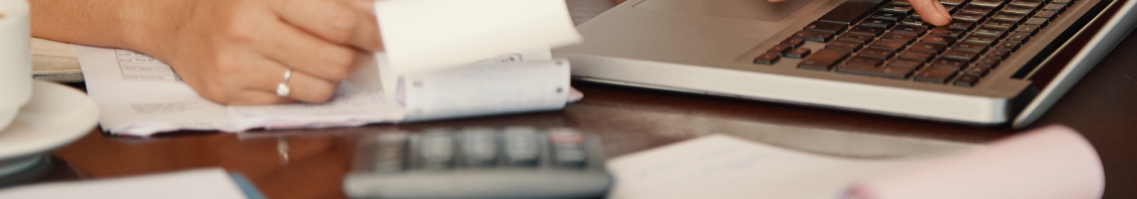a person calculating their finances using their laptop and calculator